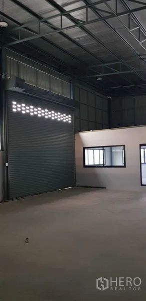 Warehouse for rent in Lat Lum Kaeo, Pathum Thani - Interior view showing a roller shutter with light vents beside the office windows.