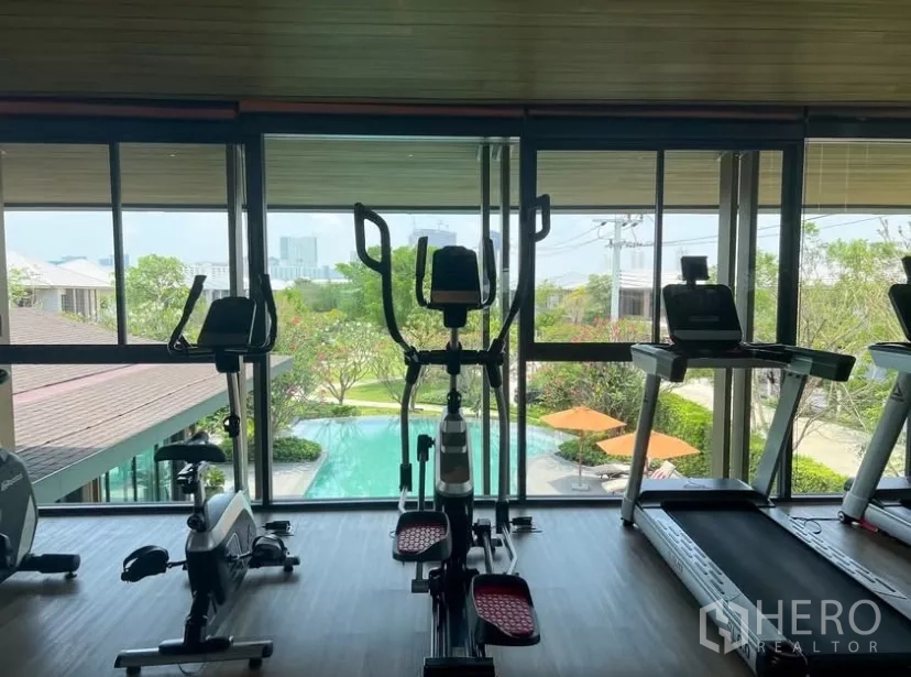 Detached House for rent or sale in Bang Kapi, Bangkok - Community fitness room with cardio equipment overlooking the swimming pool.