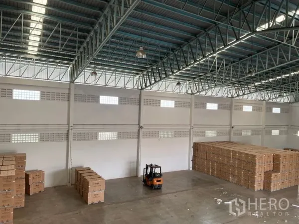 คลังสินค้า ให้เช่าในLat Krabang, Bangkok - พื้นโกดังกว้างมองจากมุมสูง มีรถโฟล์คลิฟท์และพาเลทกล่องใต้สกายไลท์