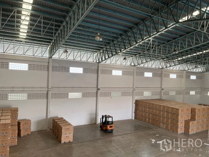 คลังสินค้า ให้เช่าในLat Krabang, Bangkok - พื้นโกดังกว้างมองจากมุมสูง มีรถโฟล์คลิฟท์และพาเลทกล่องใต้สกายไลท์