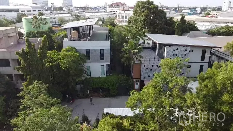 办公空间 出租在Khlong Toei, Bangkok - 俯瞰现代低层办公园区，带屋顶露台，周围绿树成荫。