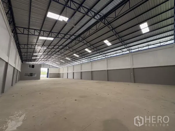 Warehouse for rent in Mueang Samut Prakan, Samut Prakan - Reverse angle showing the loading entrance and office block at the far end of the hall.