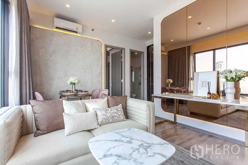 Condominium for rent in Watthana, Bangkok - Open-plan lounge with marble coffee table, accent lighting and view toward the dining area.