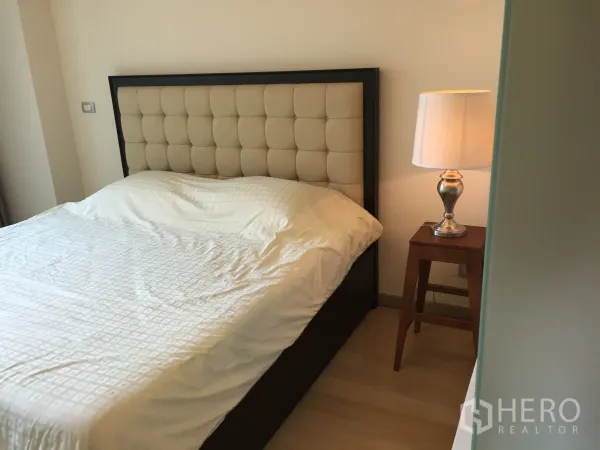 คอนโด ให้เช่าหรือขายในWatthana, Bangkok - ห้องนอนหลักพร้อมเตียงหัวเตียงบุนวม และโคมไฟข้างเตียง โทนสีอบอุ่น.