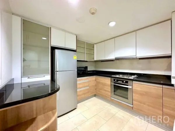 Condominium for rent - Separate U-shaped kitchen with wood cabinetry, black granite counters, oven and fridge.