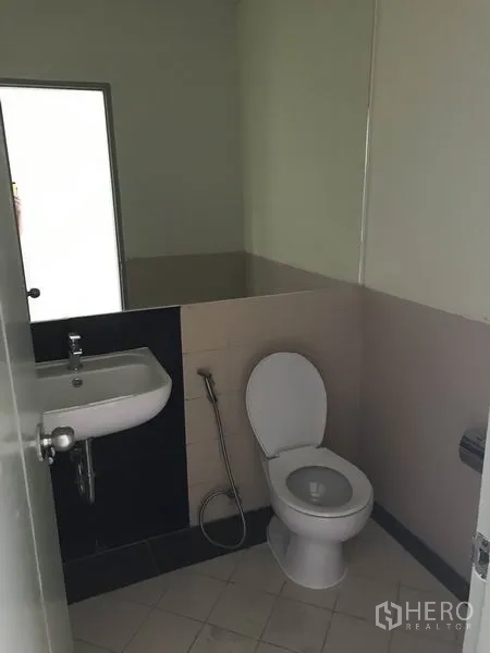 Office Space for rent in Khlong Toei, Bangkok - Private restroom with toilet, sink, and handheld bidet sprayer.
