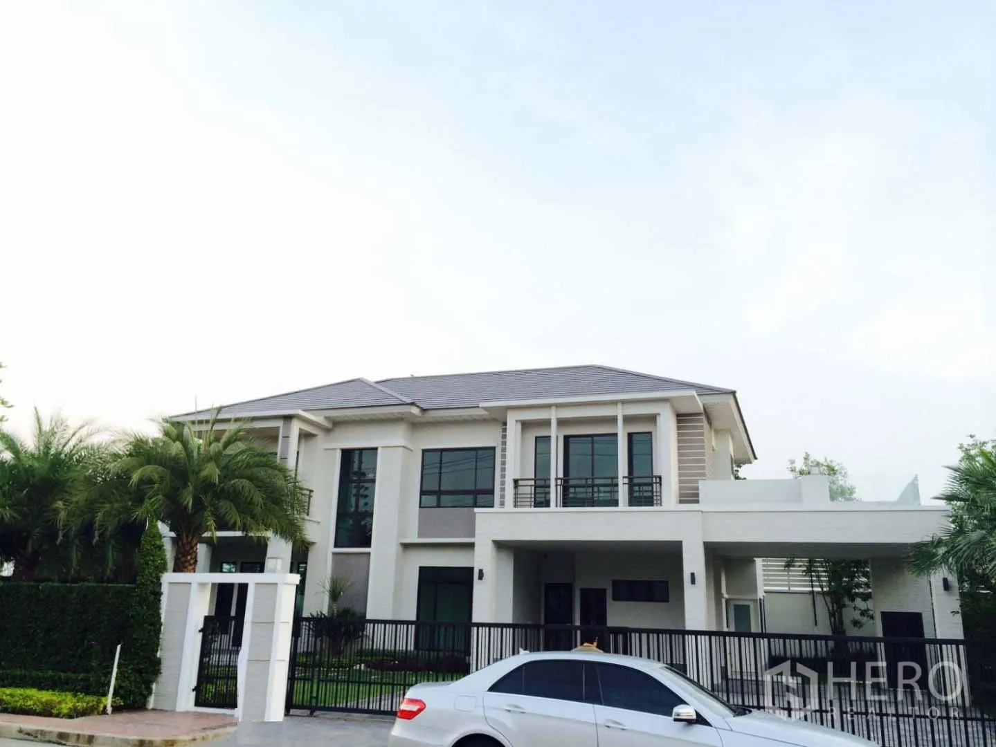 บ้าน ขายในLat Krabang, Bangkok - ด้านหน้าบ้านสองชั้นร่วมสมัย พร้อมประตูรั้วและที่จอดรถในร่ม