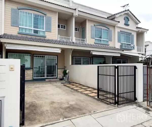 Townhouse for rent in Bang Bo, Samut Prakan - Two-storey townhouse exterior in Bang Bo with gated carport and balcony.