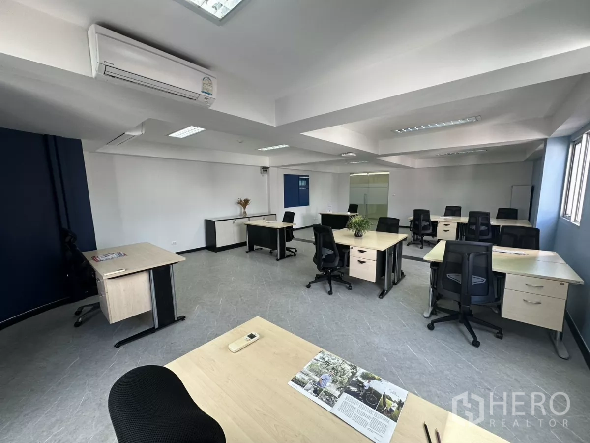 Office Space for rent in Watthana, Bangkok - Angle toward the entrance showing air-conditioning units, cabinets and neatly spaced desks.