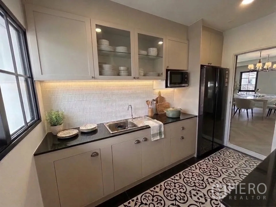 Detached House for rent in Bang Phli, Samut Prakan - Fitted kitchen with glass-front cabinets, under-cabinet lighting, tiled backsplash, and patterned floor.