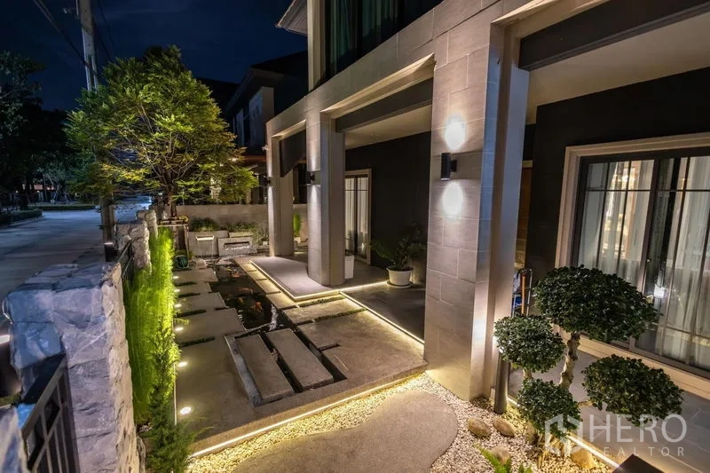 Detached House for sale in Pak Kret, Nonthaburi - Landscaped front courtyard with stepping‑stone path, water feature and night lighting.
