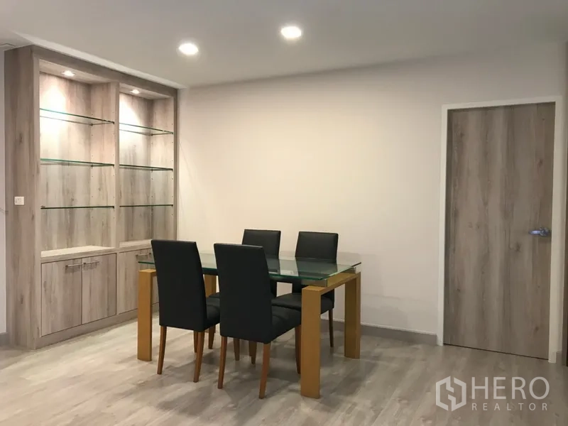 คอนโด ให้เช่าในWatthana, Bangkok - มุมรับประทานอาหารสว่างไสว โต๊ะกระจก เก้าอี้สีดำ 4 ตัว พร้อมตู้โชว์กระจกไฟในตัว