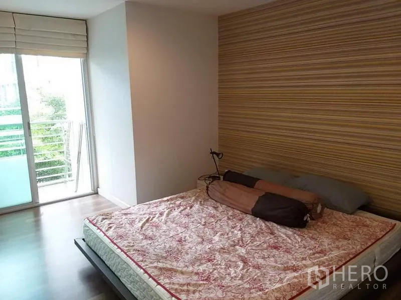 คอนโด ให้เช่าในWatthana, Bangkok - ห้องนอนหลักมีหน้าต่างบานใหญ่ ผนังลาย และประตูกระจกเปิดสู่ระเบียง