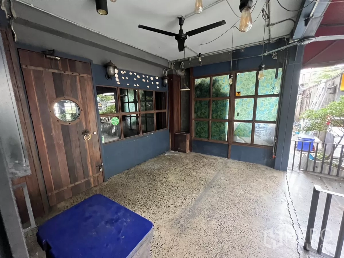 零售空间 出租 - 入口小厅，木门、爱迪生灯泡与装饰玻璃窗。