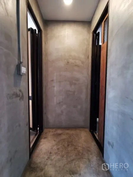 Home Office for sale in Wang Thonglang, Bangkok - Minimal concrete hallway with doorways on both sides.