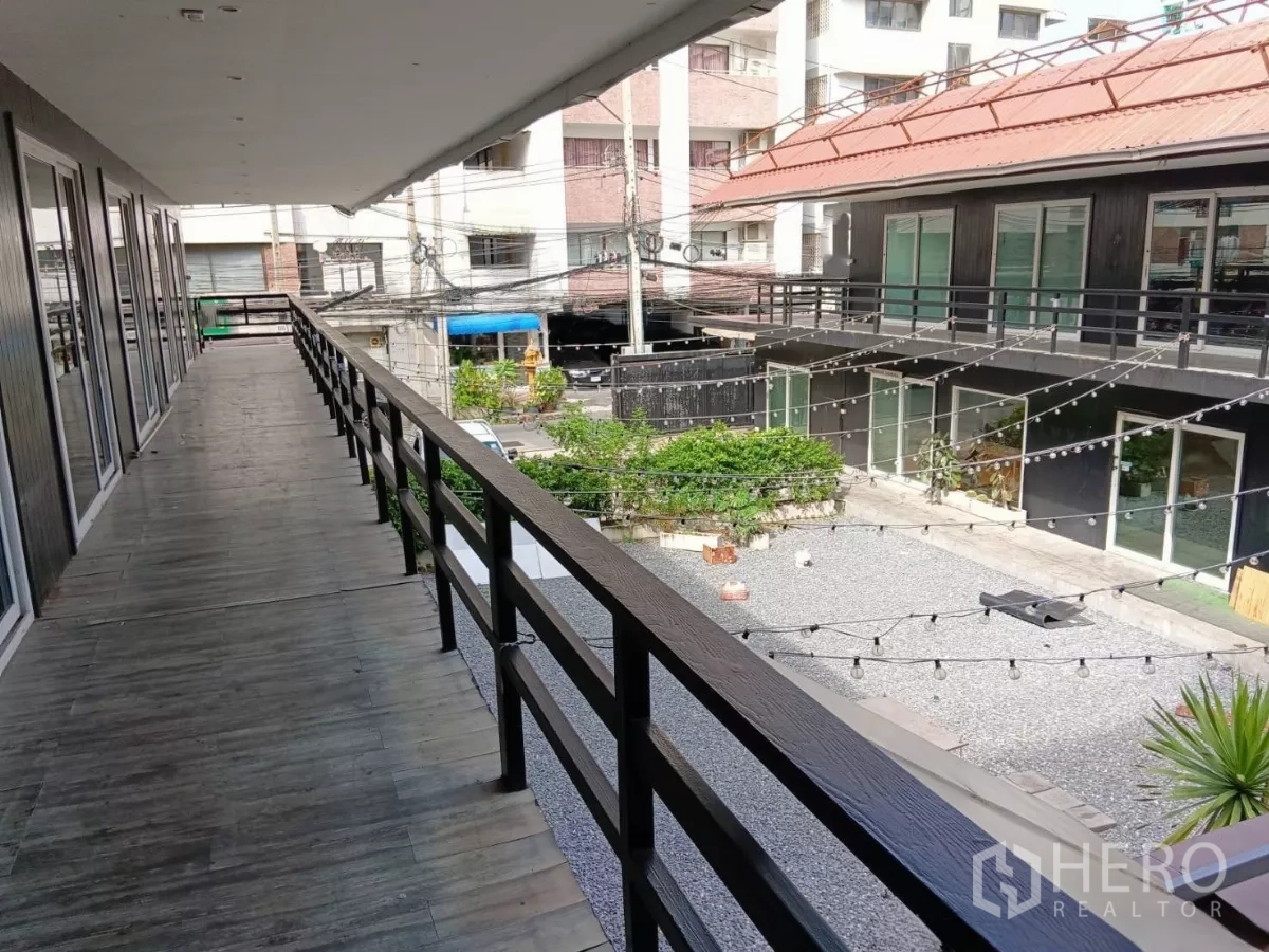 零售空间 出租在Huai Khwang, Bangkok - 二层走道带栏杆，俯瞰中央庭院与商铺单元。