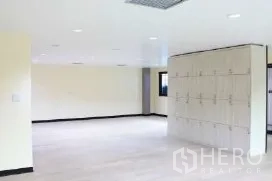 办公空间 出租在Bang Rak, Bangkok - 开放式办公区，吊顶灯光与内置储物柜。