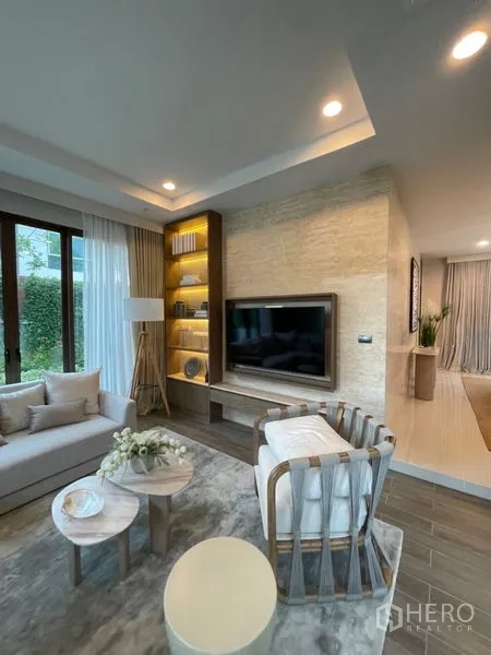 Detached House for sale in Bang Kapi, Bangkok - Living area featuring TV wall, built-in shelving and recessed lighting in neutral tones.