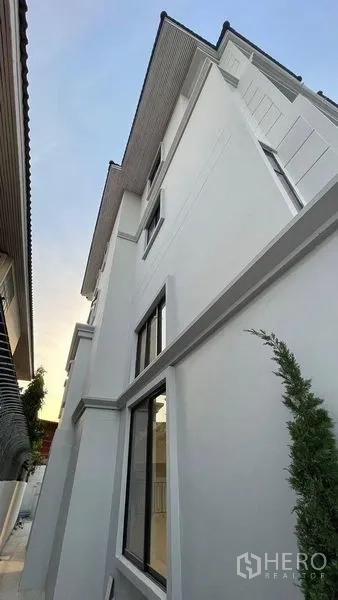 联排别墅 出售在Prawet, Bangkok - 现代白色联排外立面，大窗与人字屋顶。