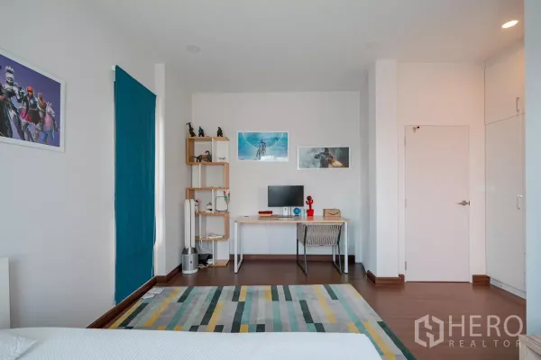 บ้าน ขายในSaphan Sung, Bangkok - มุมทำงานในห้องนอนพร้อมโต๊ะ ชั้นวาง และงานศิลป์ติดผนัง