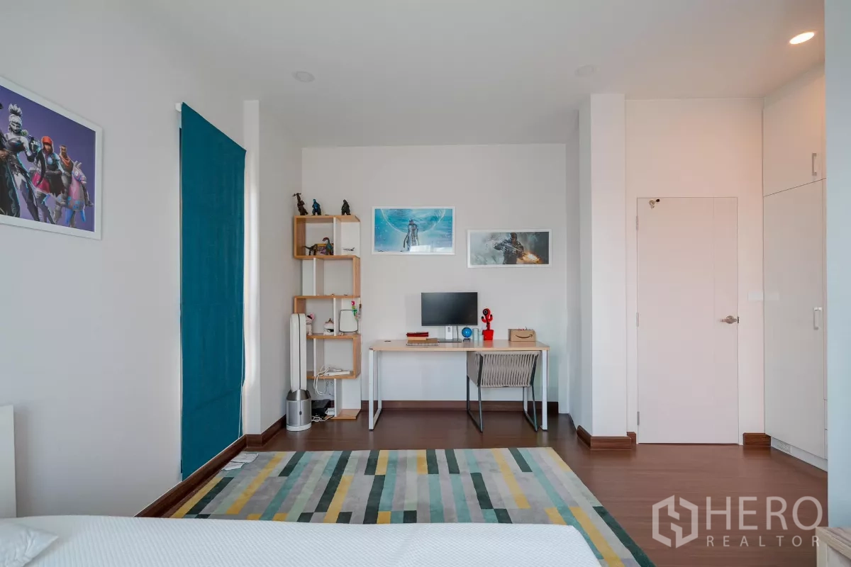 บ้าน ขายในSaphan Sung, Bangkok - มุมทำงานในห้องนอนพร้อมโต๊ะ ชั้นวาง และงานศิลป์ติดผนัง