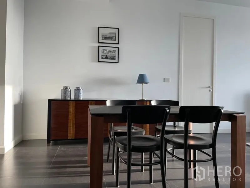 คอนโด ให้เช่าหรือขายในPathum Wan, Bangkok - โซนทานข้าว โต๊ะไม้พร้อมเก้าอี้สี่ตัว ข้างตู้คอนโซลและกรอบรูปตกแต่ง