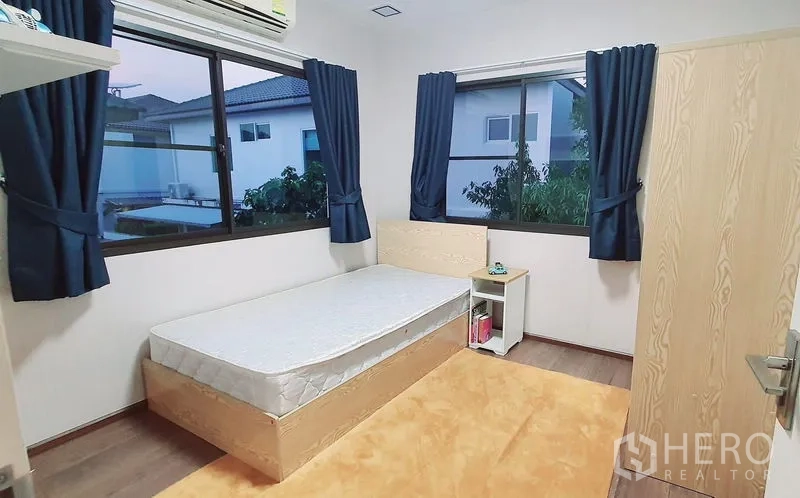 Detached House for rent in Bang Phli, Samut Prakan - Cozy bedroom with single bed, blue curtains and corner windows