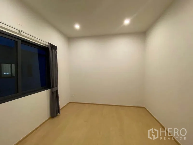 ทาวน์เฮาส์ ให้เช่าในPrawet, Bangkok - ห้องนอนโล่งสว่าง พื้นลายไม้ ไฟดาวน์ไลต์ และหน้าต่างม่านทึบ