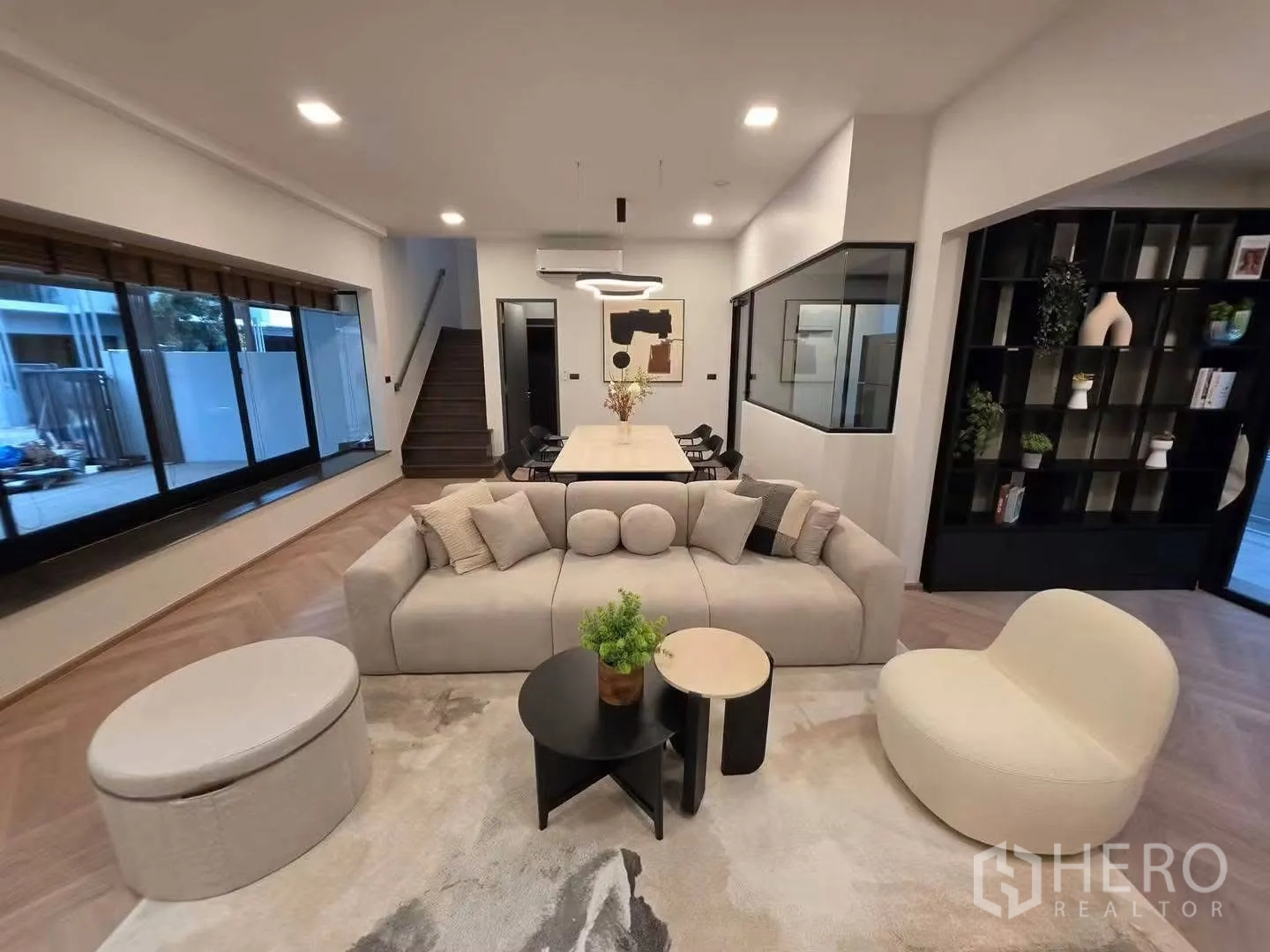 ทาวน์เฮาส์ for rent in Bang Phli, Samut Prakan - มุมมองกว้างของโซนพักผ่อนเห็นบันได หน้าต่างบานใหญ่ ชุดทานอาหาร และชั้นวางสีดำ
