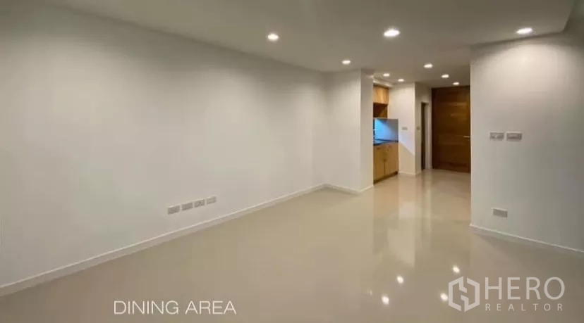 Detached House for rent in Huai Khwang, Bangkok - Open dining space with smooth white walls, recessed ceiling lights and glossy flooring.