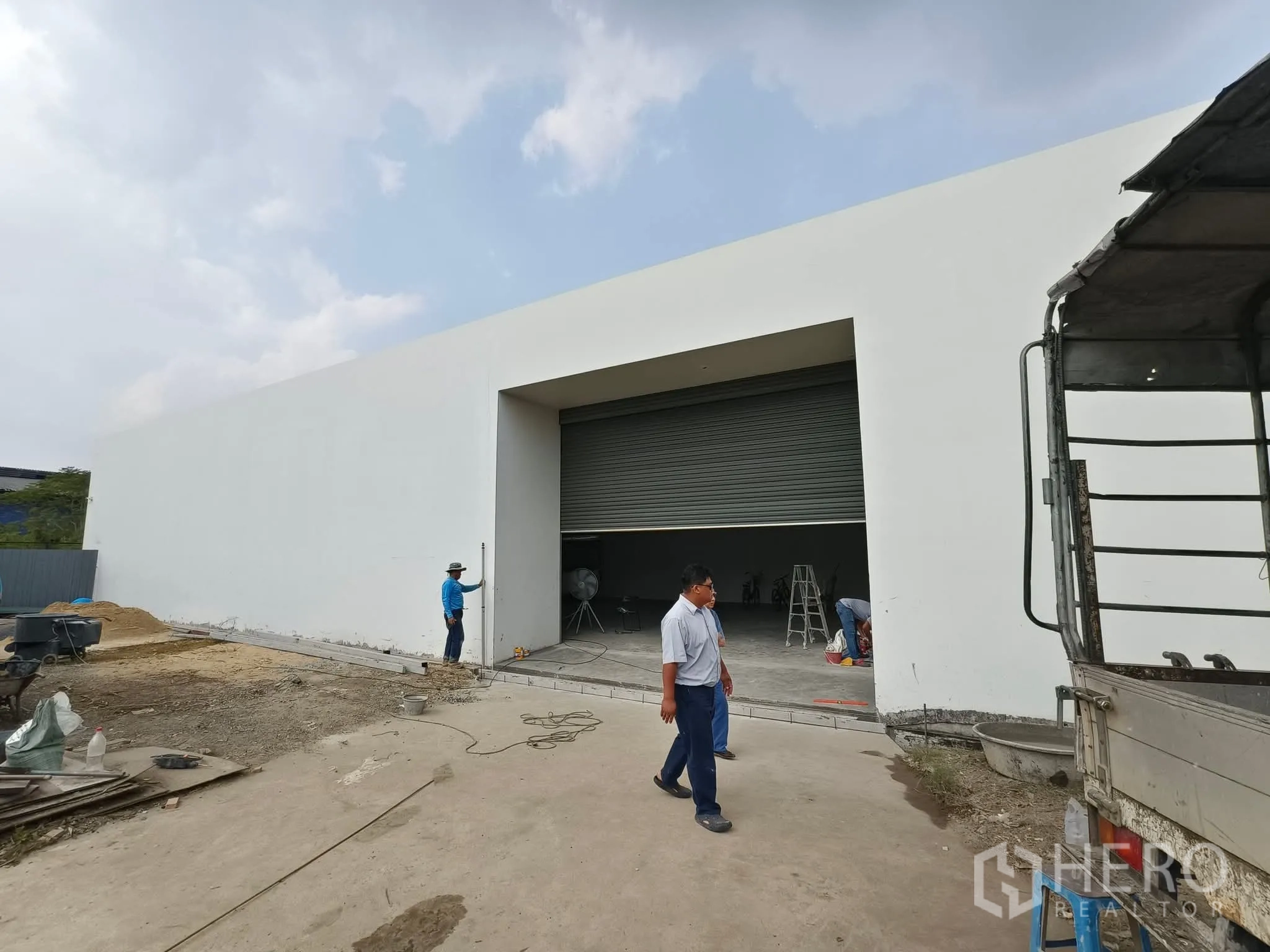 Warehouse for rent in Sai Mai, Bangkok - Modern white warehouse exterior featuring an oversized roller shutter and loading apron.