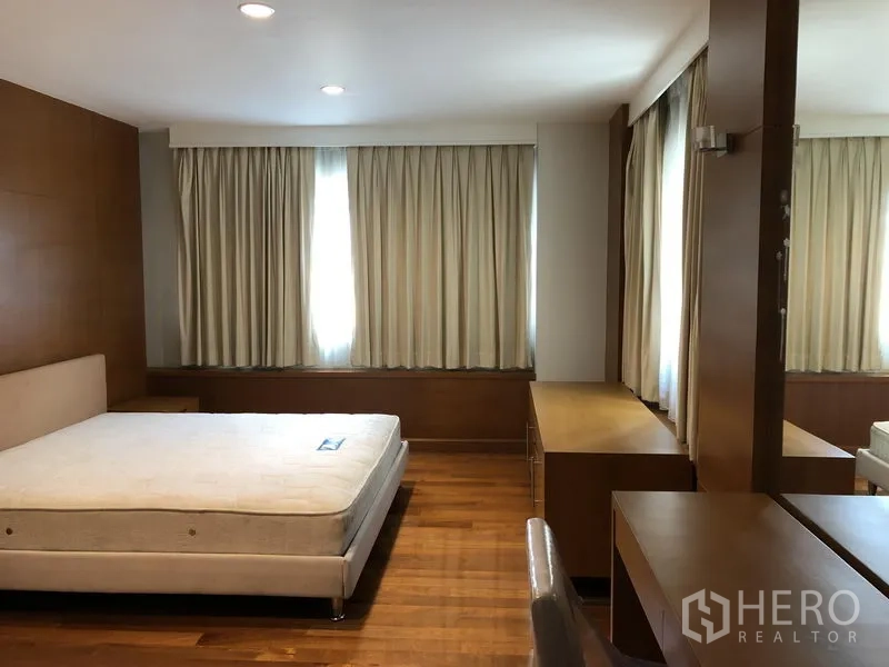Detached House for rent in Watthana, Bangkok - Spacious master bedroom with wood floors, built-in wardrobes and dressing desk.