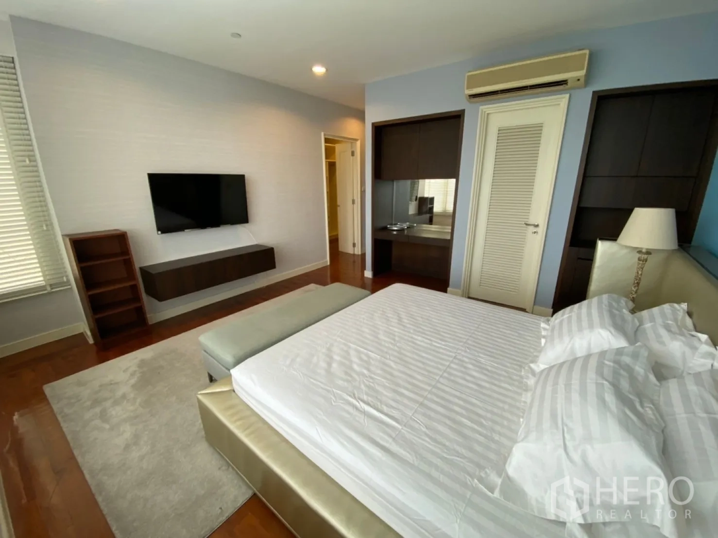 Condominium for rent in Watthana, Bangkok - Master bedroom from opposite angle with wall-mounted TV and built-in storage.