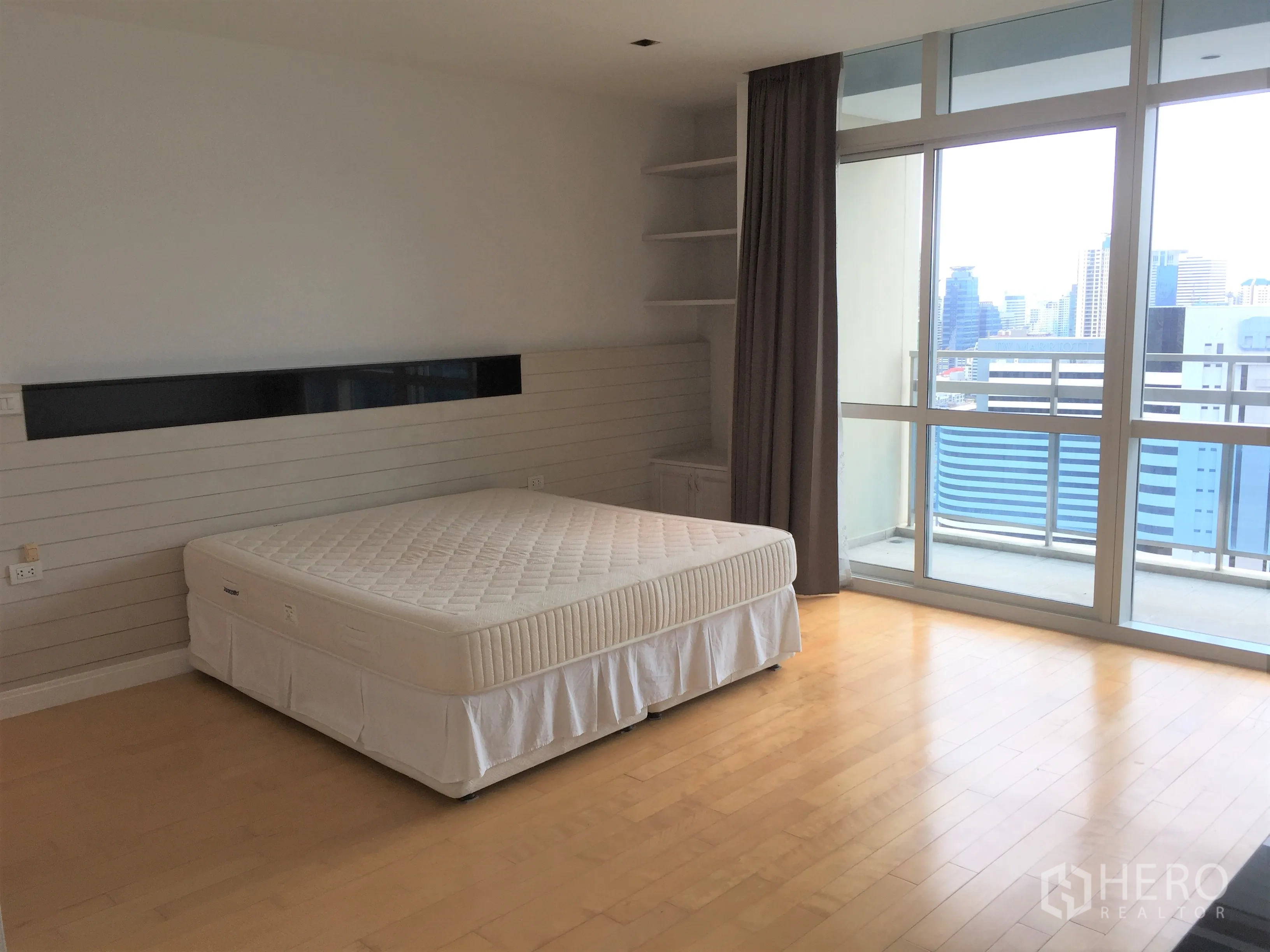 Condominium for rent in Pathum Wan, Bangkok - Bedroom with large windows and balcony overlooking the Bangkok skyline.