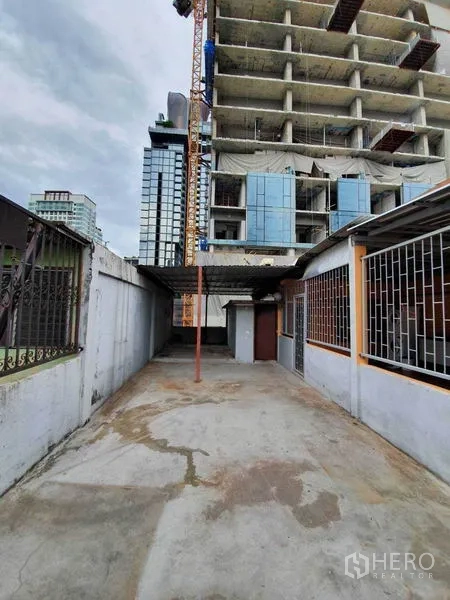 店屋 出租在Watthana, Bangkok - 后方混凝土庭院，带部分遮棚，邻近高楼施工。