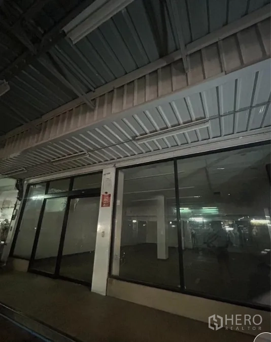零售空间 出租在Suan Luang, Bangkok - 金属雨棚下的宽幅玻璃入口与橱窗。