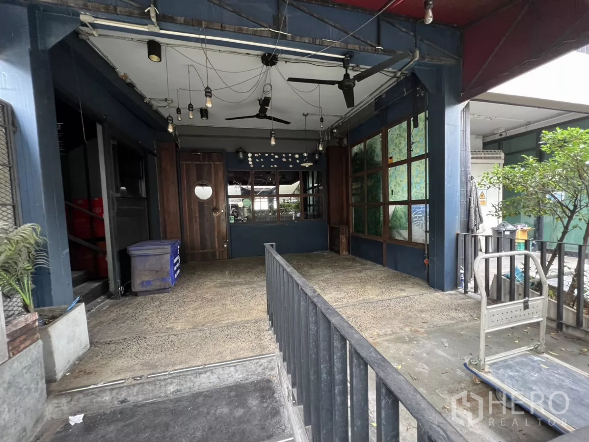 零售空间 出租 - 前庭带无障碍坡道、木门、吊扇与窗格。