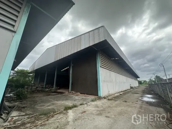 工厂 出售在Bang Bua Thong, Nonthaburi - 大角度展示钢结构屋顶的工厂，带滑动门与车辆通道，位于邦武通。