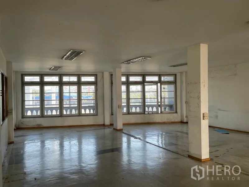 货栈 出租在Prawet, Bangkok - 大开间办公室，成排宽窗与结构柱。