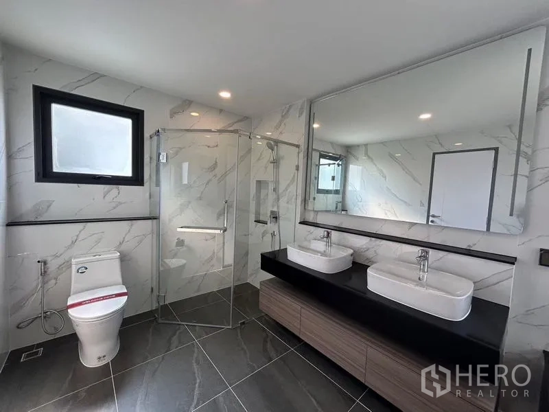 Detached House for rent - Ensuite bathroom featuring double sinks, frameless glass shower, and large mirror.