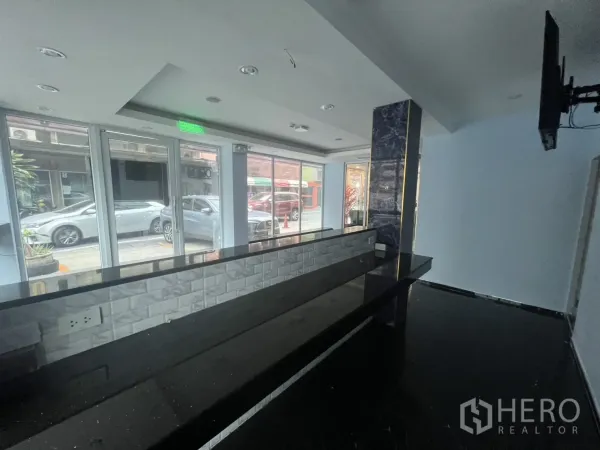 零售空间 出租在Khlong Toei, Bangkok - 临街零售室内，整面落地玻璃、长服务台与吊顶射灯，位于空堤区。