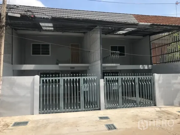 สำนักงานที่บ้าน ให้เช่าในPhra Khanong, Bangkok - ด้านหน้าโฮมออฟฟิศสไตล์ทาวน์เฮาส์ 2 ชั้น ประตูรั้วเหล็กคู่และที่จอดรถในร่มใต้หลังคากระเบื้อง