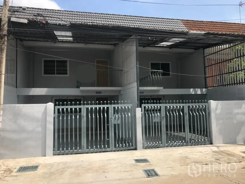 สำนักงานที่บ้าน ให้เช่าในPhra Khanong, Bangkok - ด้านหน้าโฮมออฟฟิศสไตล์ทาวน์เฮาส์ 2 ชั้น ประตูรั้วเหล็กคู่และที่จอดรถในร่มใต้หลังคากระเบื้อง