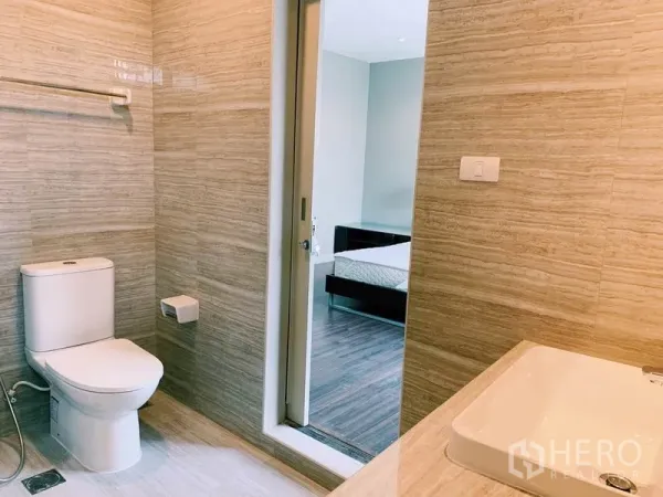 คอนโด ให้เช่าในWatthana, Bangkok - ห้องน้ำโทนสว่างพร้อมโถสุขภัณฑ์และอ่างล้างหน้า เชื่อมกับห้องนอนด้วยประตูบานเลื่อน