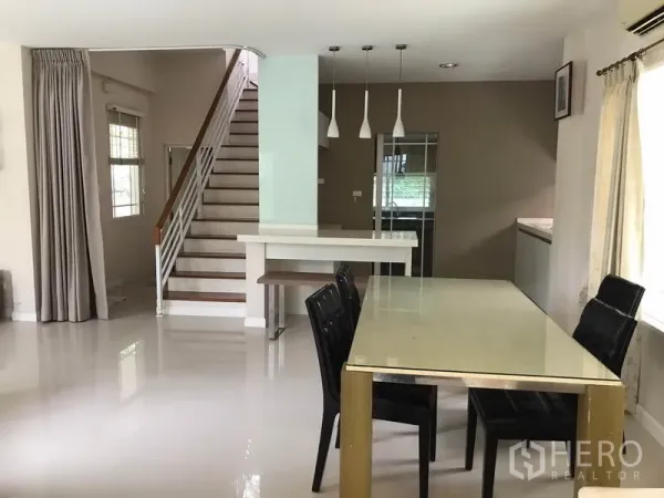 Detached House for rent in Khlong Sam Wa, Bangkok - Dining area facing the staircase with pendant lights and pantry counter.