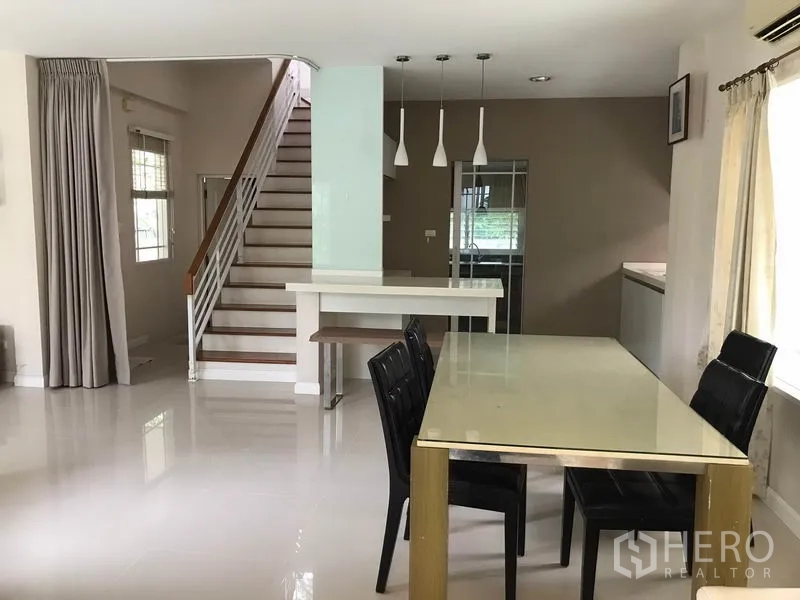 Detached House for rent in Khlong Sam Wa, Bangkok - Dining area facing the staircase with pendant lights and pantry counter.
