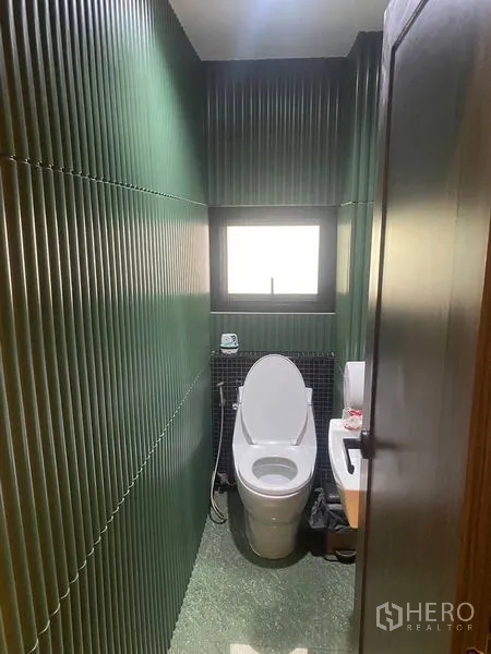 อาคารพาณิชย์ ให้เช่า - ห้องน้ำขนาดกะทัดรัด ผนังลอนสีเขียว มีหน้าต่างและโถสุขภัณฑ์