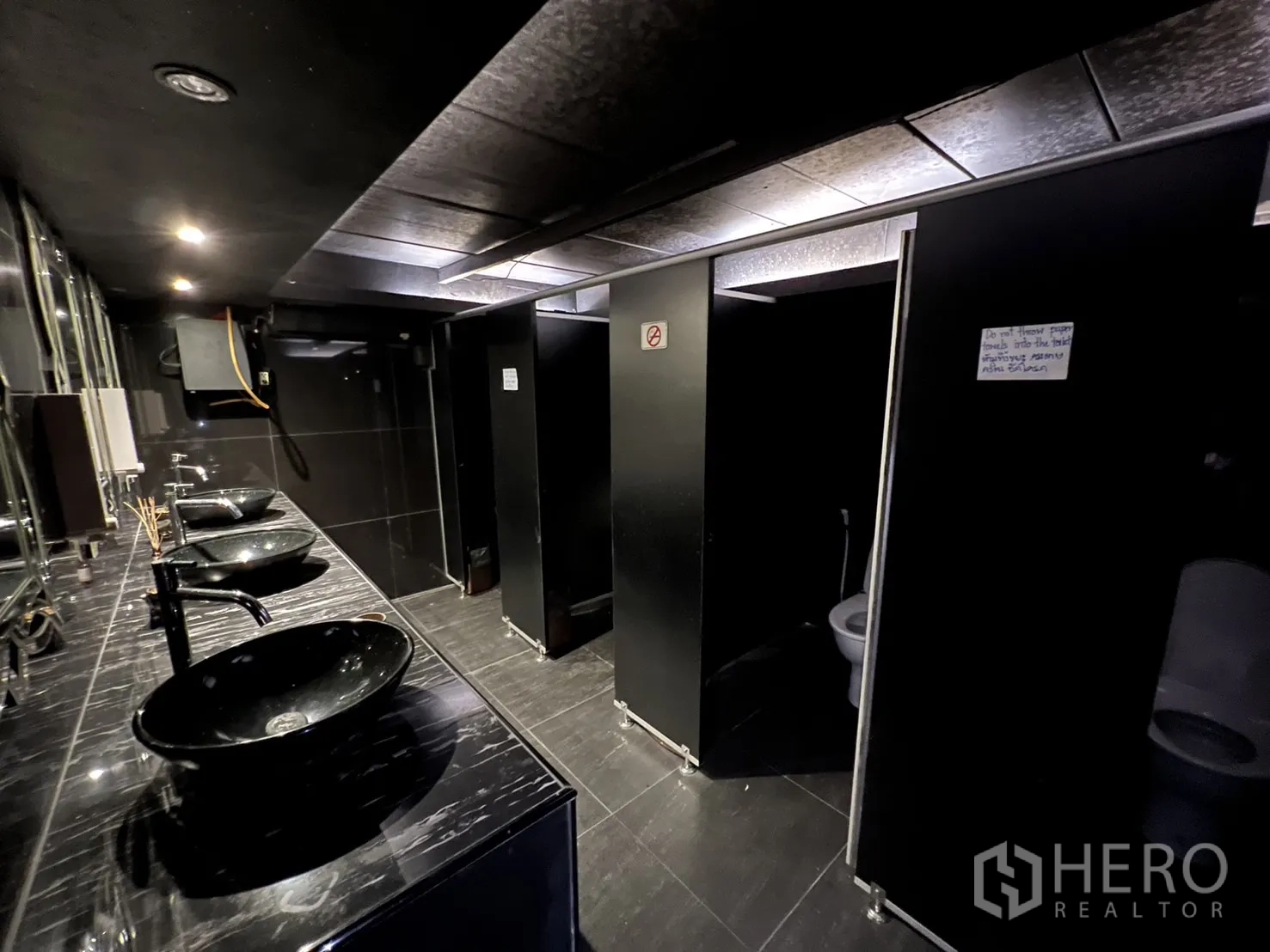 零售空间 出租 - 现代化洗手间，黑色台盆、镜面与隔间。