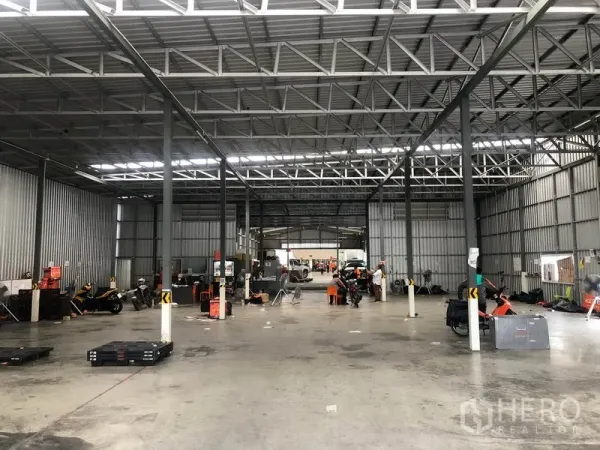 Warehouse for rent in Don Mueang, Bangkok - Spacious warehouse interior with steel trusses, open concrete floor and bright strip lighting.