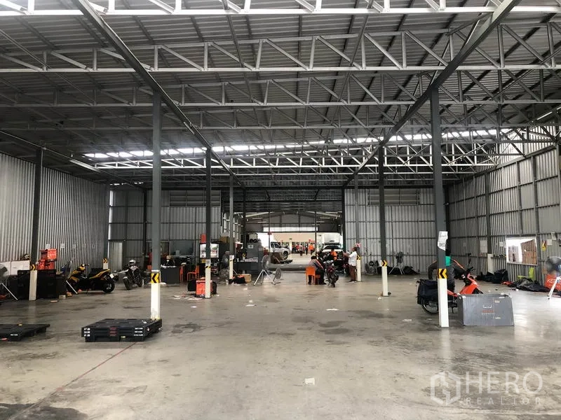 Warehouse for rent in Don Mueang, Bangkok - Spacious warehouse interior with steel trusses, open concrete floor and bright strip lighting.